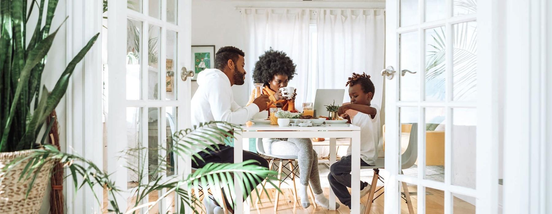 young family of three eat together at the breakfast table